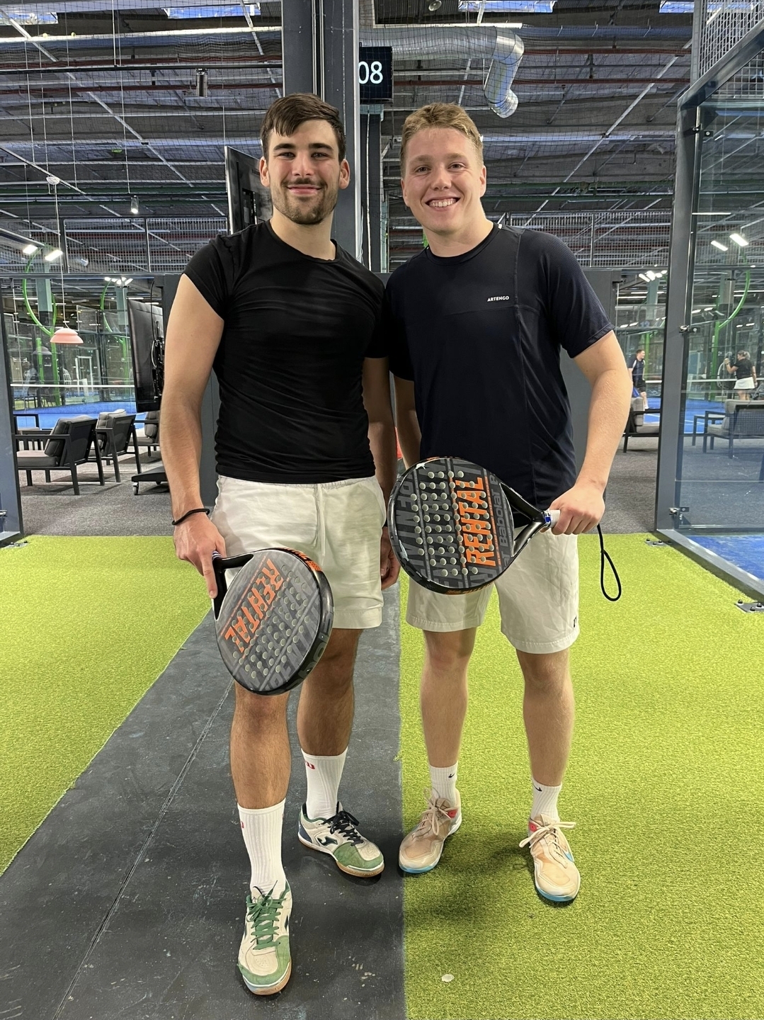 Joonas and another player holding rackets at an indoor padel court.